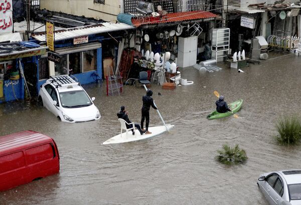 Lebanese men use a paddle board and canoe as means of transportation on a flooded road due to heavy rain, at the southern entrance of the capital Beirut on December 9, 2019 - Sputnik International