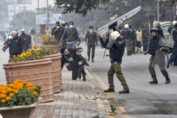 A policeman prepares to beat a lawyer (C) following a clash between lawyers and doctors in Lahore on December 11, 2019 - Sputnik International