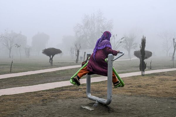 A woman exercises in a park amid fog in Srinagar on December 10, 2019 - Sputnik International