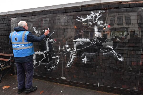 A council worker cleans the perspex covering an artwork by British artist Banksy that appeared overnight in Birmingham on December 10, 2019 - Sputnik International