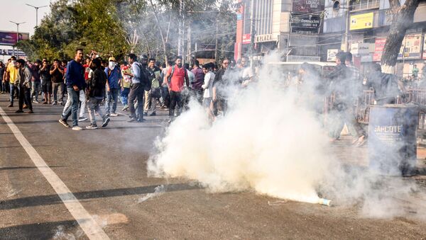Police personnel fire tear gas to disperse the students protesting against the government's Citizenship Amendment Bill (CAB), during a demonstration in Guwahati on December 11, 2019 - Sputnik International