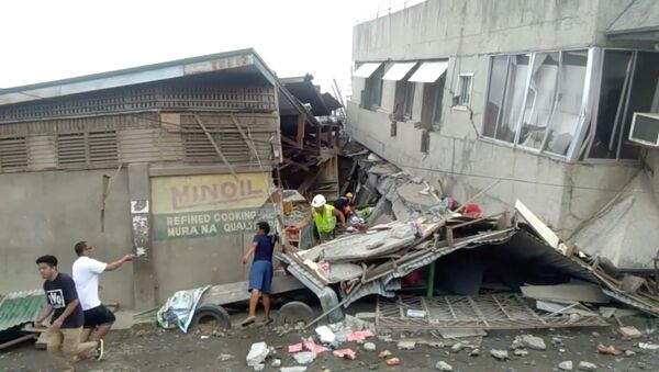 Rescue crew members look for trapped victims at collapsed building at Padada market, in Padada - Sputnik International