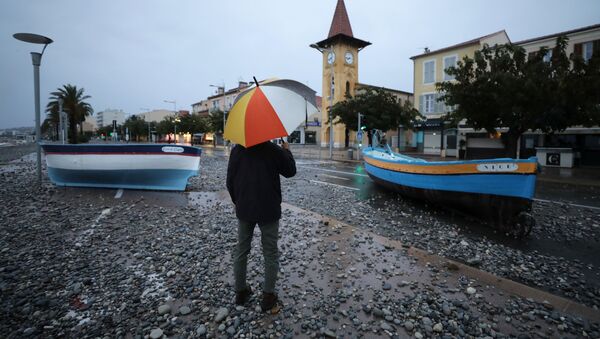 A man looks at fishing boats stuck on a street after heavy rain fall in Cagnes-sur-Mer, France - Sputnik International