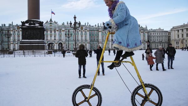 A woman wearing a Snow Maiden costume rides a bike during celebration Old New Year at Dvortsovaya (Palace) Square in St.Petersburg, Russia, Sunday, Jan. 13, 2019.  - Sputnik International