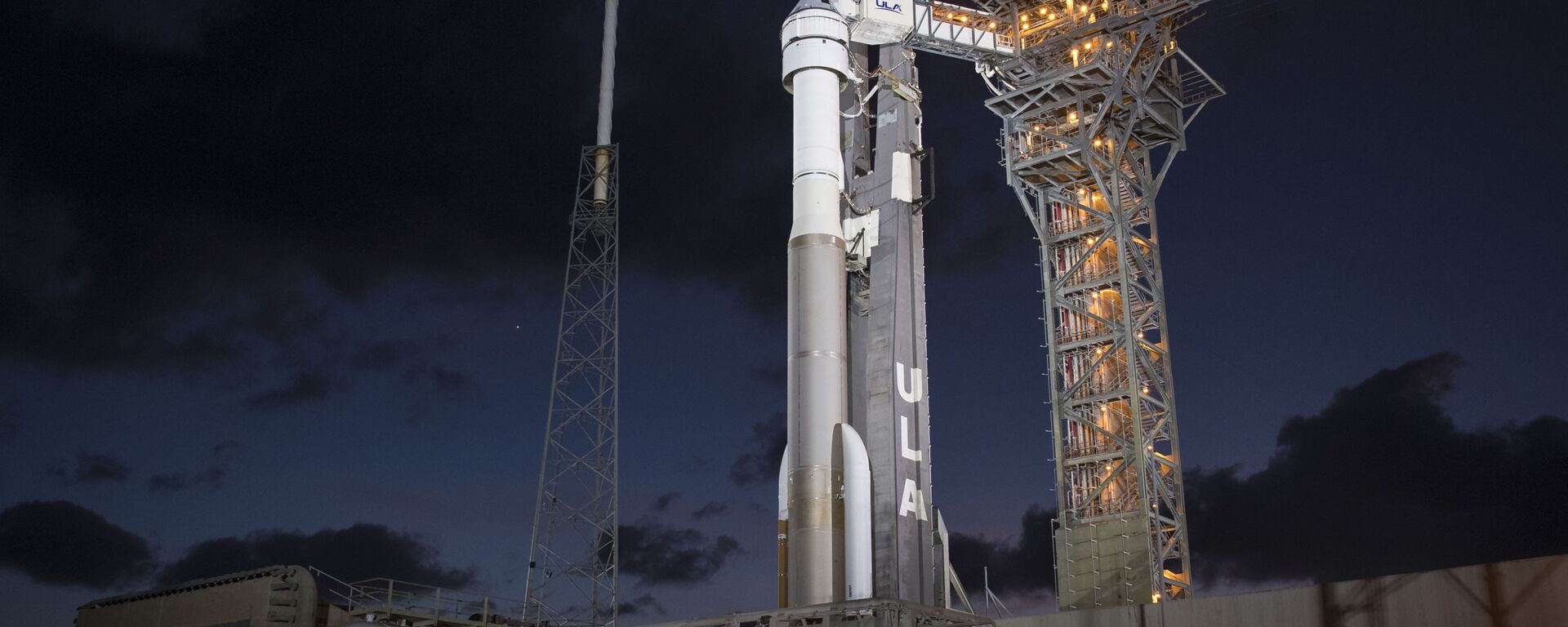 A United Launch Alliance Atlas V rocket with Boeing's CST-100 Starliner spacecraft onboard is seen illuminated by spotlights on the launch pad at Space Launch Complex 41 ahead of the Orbital Flight Test mission, Wednesday, Dec. 18, 2019 at Cape Canaveral Air Force Station in Florida - Sputnik International, 1920, 17.07.2021