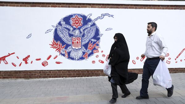 People walk past a satirical drawing of the Great Seal of the United States after new anti-U.S. murals on the walls of former U.S. embassy unveiled in a ceremony in Tehran, Iran, Saturday, Nov. 2, 2019 - Sputnik International