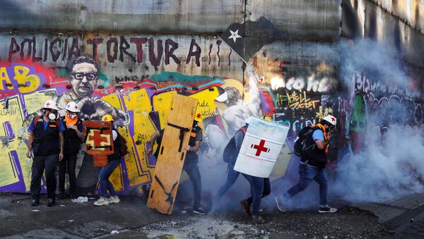 Medical volunteers move amid tear gas during a protest against Chile's government in Santiago, Chile December 20, 2019 - Sputnik International