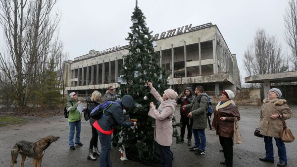 Former residents of Pripyat located near the Chernobyl Nuclear Power Plant decorate a Christmas tree, which was installed in the main square of the ghost town for the first time since 1985, in Pripyat, Ukraine December 25, 2019 - Sputnik International
