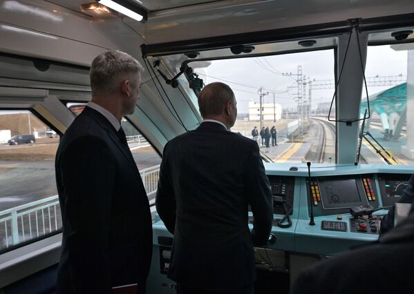 Russian President Vladimir Putin (R) and Russian Minister of Transport Yevgeny Dietrich look through the window in a railbus which is about to make its first trip across the Crimea Bridge. - Sputnik International