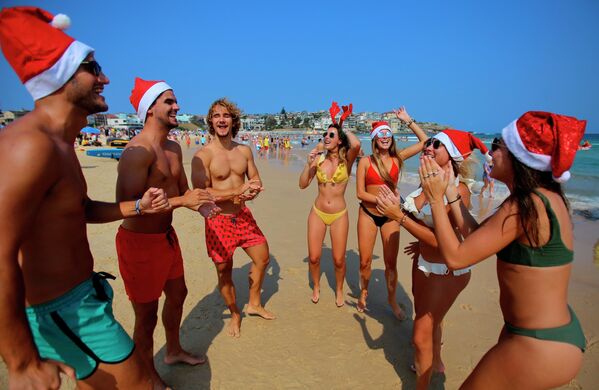 Tourists in Christmas costumes on a beach in Sydney - Sputnik International