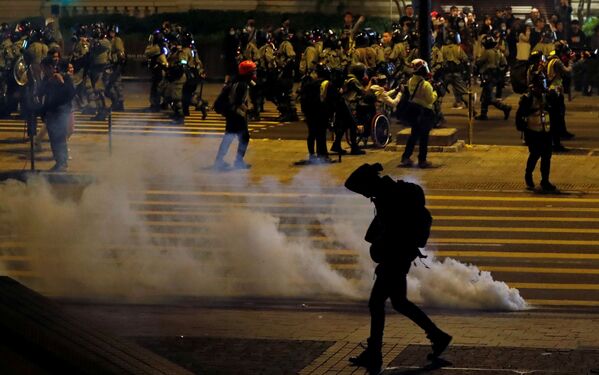 An anti-government demonstrator walks past tear gas on Christmas Eve in Hong Kong, China, 24 December 2019. - Sputnik International