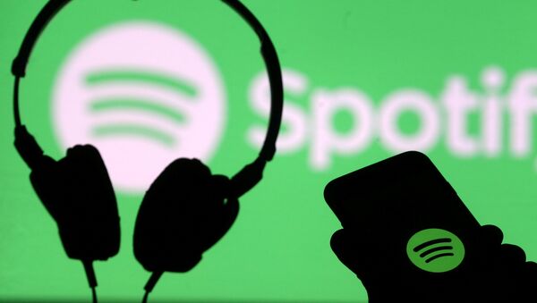 A smartphone and a headset in front of Spotify logo - Sputnik International