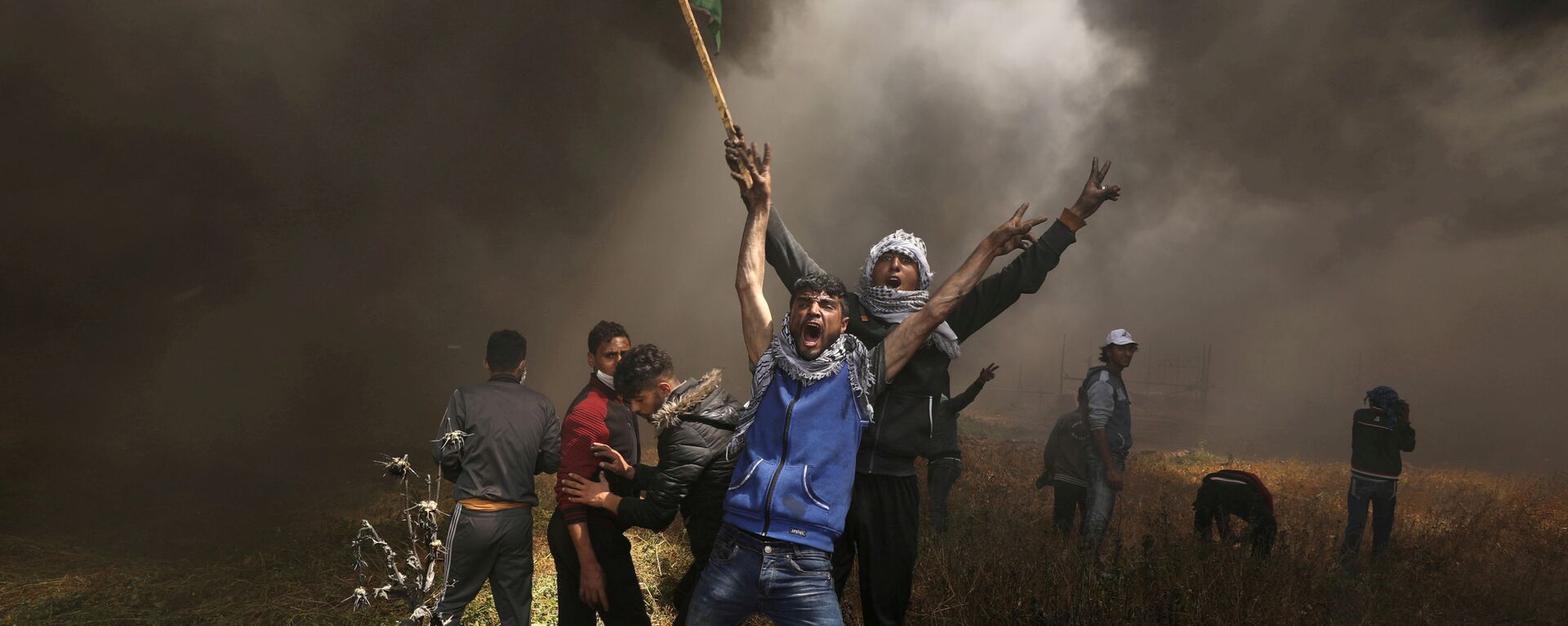 Palestinian demonstrators shout during clashes with Israeli troops at a protest demanding the right to return to their homeland, at the Israel-Gaza border east of Gaza City April 6, 2018. - Sputnik International, 1920, 29.12.2019