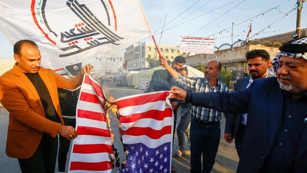Iraqi people burn a U.S. flag in a protest after an airstrike at the headquarters of Kataib Hezbollah militia group in Qaim - Sputnik International