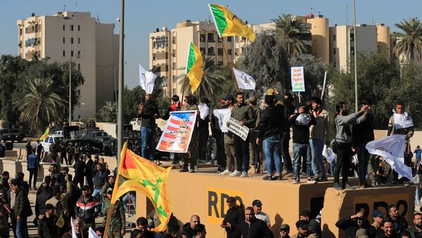 Protesters and militia fighters gather to condemn air strikes on bases belonging to Hashd al-Shaabi (paramilitary forces), outside the main gate of the U.S. Embassy in Baghdad, Iraq December 31, 2019 - Sputnik International