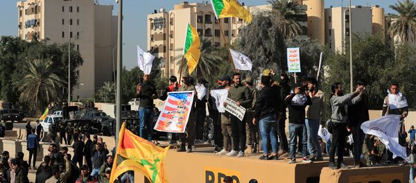 Protesters and militia fighters gather to condemn air strikes on bases belonging to Hashd al-Shaabi (paramilitary forces), outside the main gate of the U.S. Embassy in Baghdad, Iraq December 31, 2019 - Sputnik International