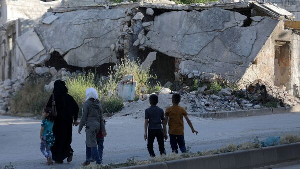 People walk near rubble of damaged buildings in the city of Idlib, Syria May 27, 2019. Picture taken May 27, 2019. - Sputnik International