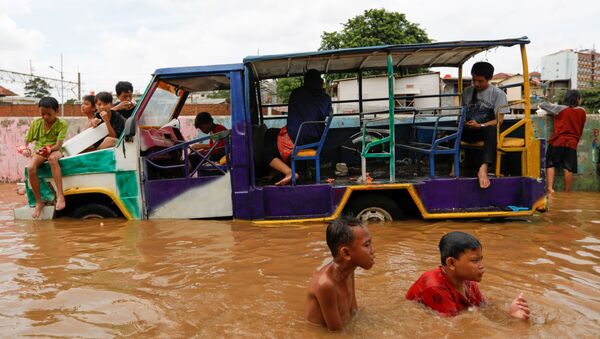 Children play at an area flooded after heavy rains in Jakarta, Indonesia - Sputnik International