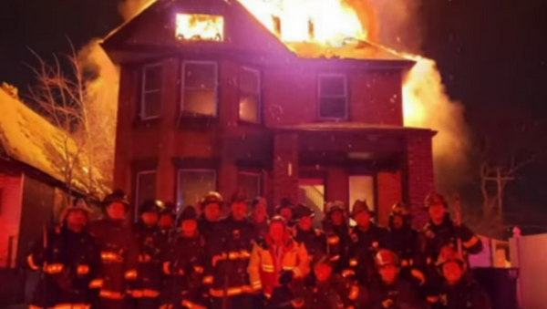 Officials with Michigan's Detroit Fire Department have come under fire after posing for a picture in front of a burning, vacant home to celebrate the retirement of a battalion chief. - Sputnik International