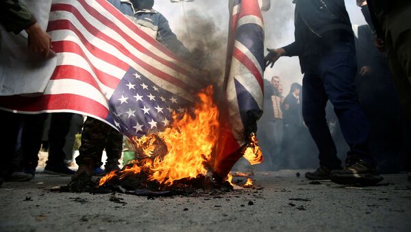 Demonstrators burn the U.S. and British flags during a protest against the assassination of the Iranian Major-General Qassem Soleimani, head of the elite Quds Force, and Iraqi militia commander Abu Mahdi al-Muhandis who were killed in an air strike in Baghdad airport, in Tehran, Iran January 3, 2020 - Sputnik International