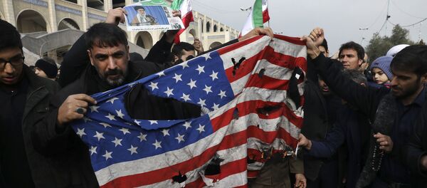 Protesters burn a U.S. flag during a demonstration over the U.S. airstrike in Iraq - Sputnik International