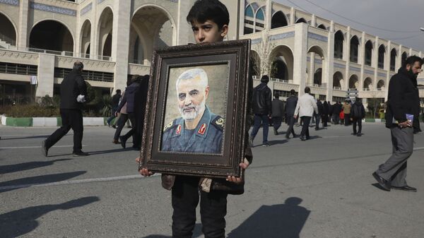 A boy carries a portrait of Iranian Revolutionary Guard Gen. Qassem Soleimani - Sputnik International