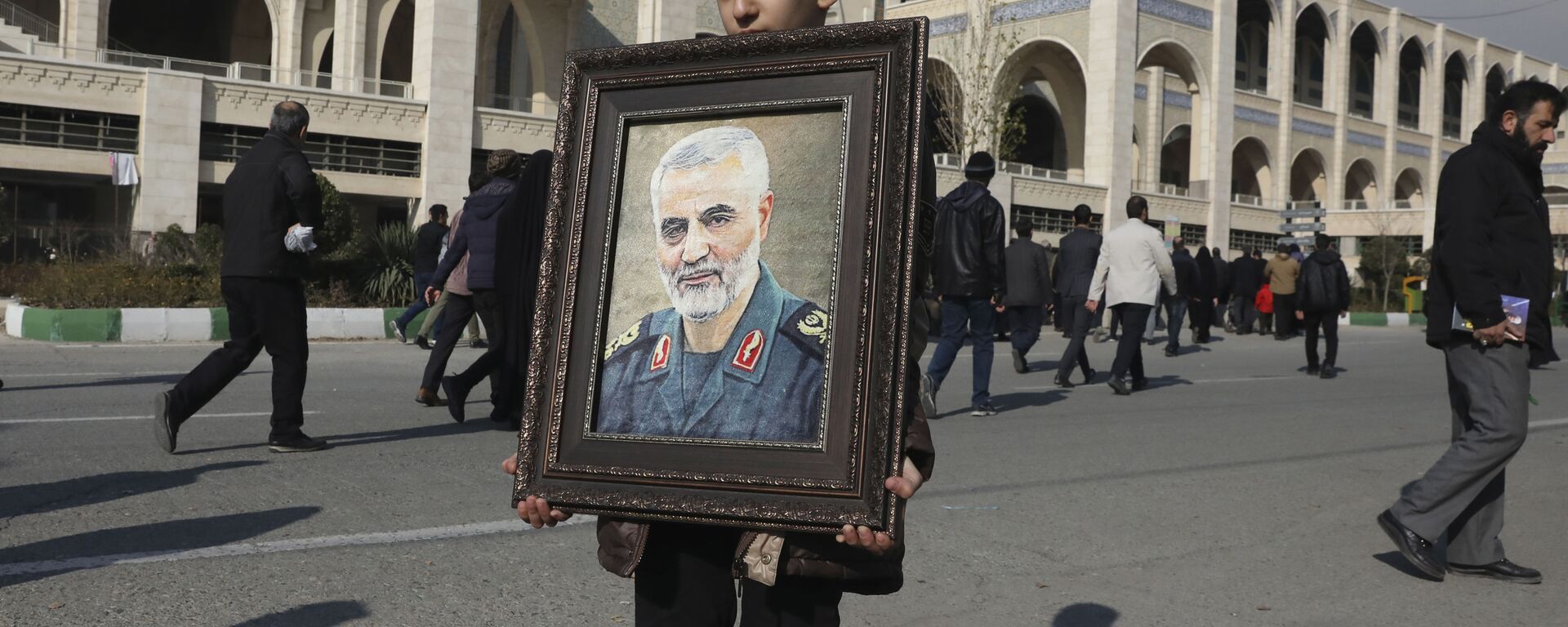 A boy carries a portrait of Iranian Revolutionary Guard Gen. Qassem Soleimani - Sputnik International, 1920, 03.01.2022