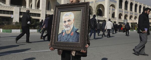 A boy carries a portrait of Iranian Revolutionary Guard Gen. Qassem Soleimani - Sputnik International
