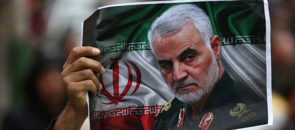 An Iranian holds a picture of late General Qassem Soleimani, head of the elite Quds Force, who was killed in an air strike at Baghdad airport, as people gather to mourn him in Tehran, Iran January 4, 2020.  - Sputnik International