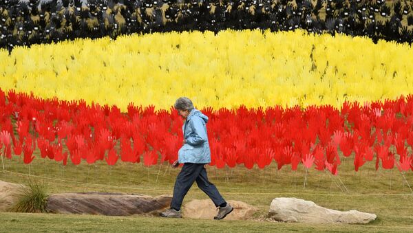 A woman passes a huge art installation called 'Sea of Hands' which consists of thousands of hands in the colours of the Aboriginal flag – red, yellow, black. - Part of National Reconciliation Week 2016, the installation is for Australians to reflect on Australia’s national identity and the place of Aboriginal and Torres Strait Islander histories and cultures in the nation’s story.  - Sputnik International