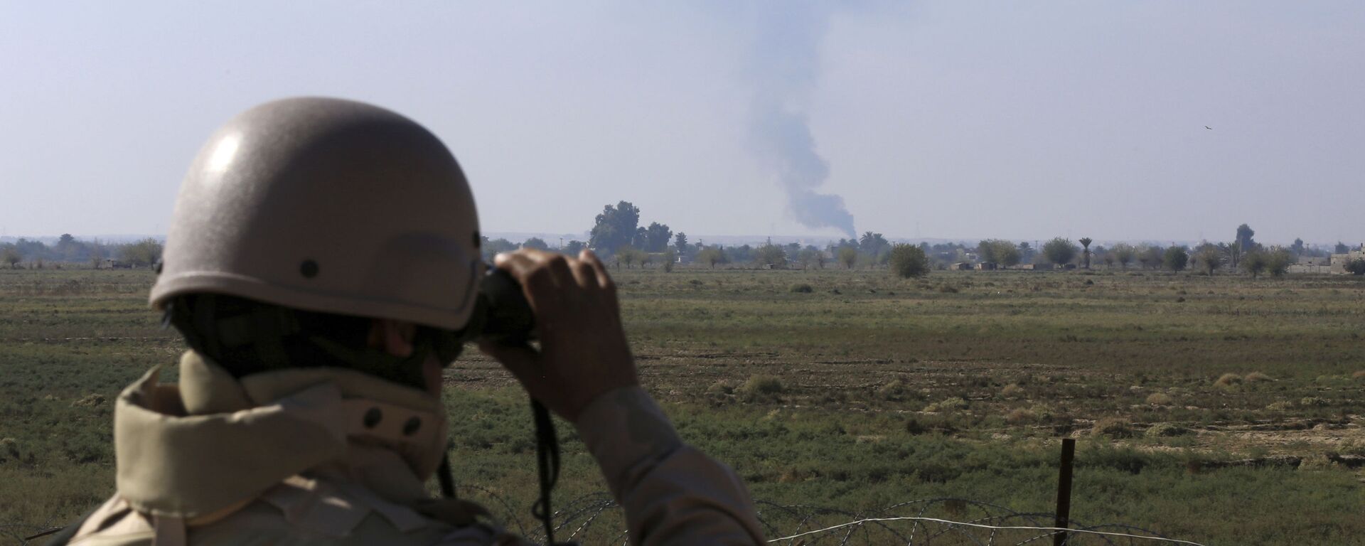 In this Tuesday, Nov. 13, 2018 photo, an Iraqi soldier watches smoke rising after an airstrike by US-led International coalition warplanes against ISIS, on the border between Syria and Iraq in Qaim, Anbar province, Iraq. - Sputnik International, 1920, 01.02.2024