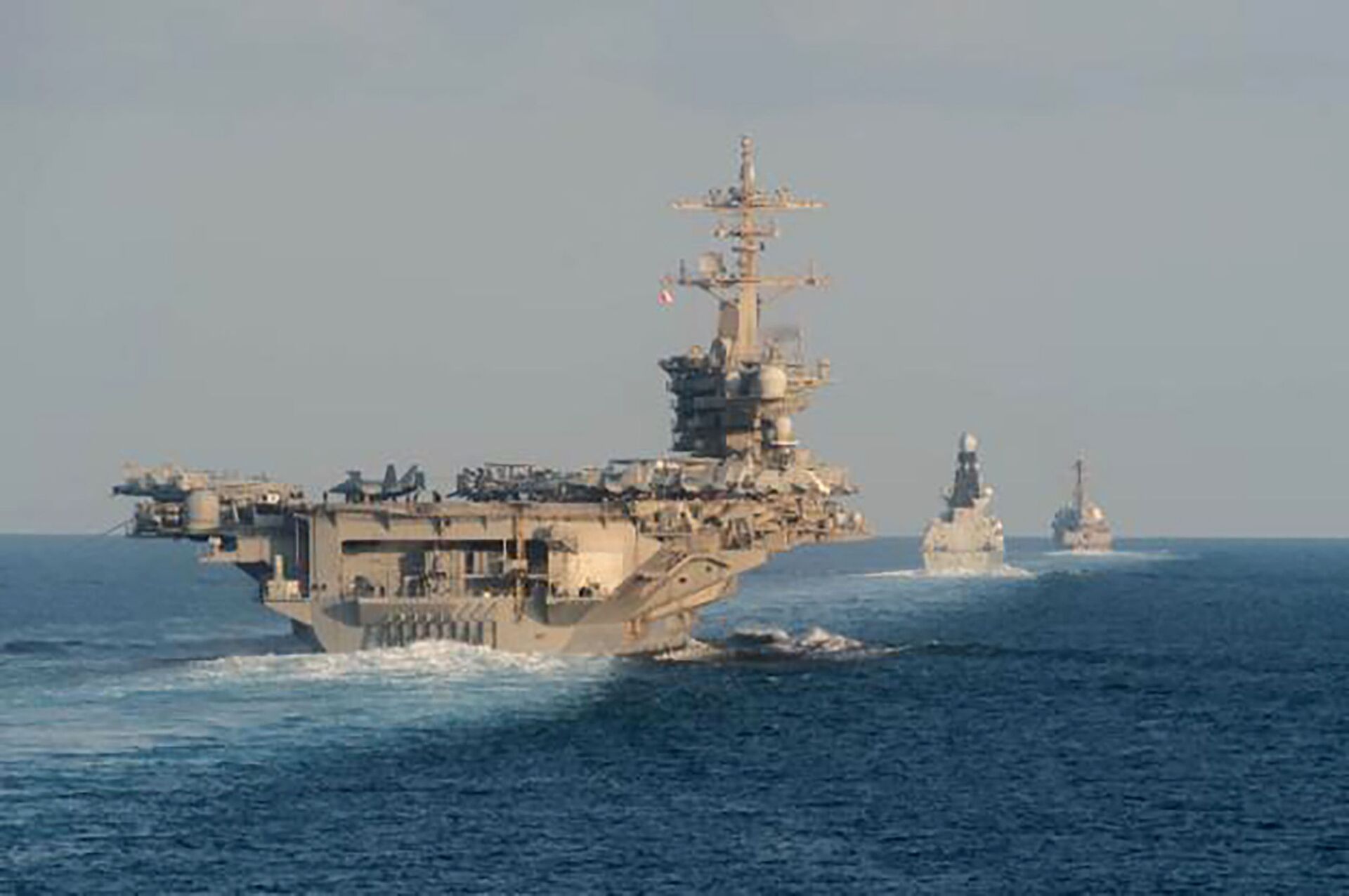 In this Tuesday, Nov. 19, 2019, photo made available by U.S. Navy, the aircraft carrier USS Abraham Lincoln, left, the air-defense destroyer HMS Defender and the guided-missile destroyer USS Farragut transit the Strait of Hormuz with the guided-missile cruiser USS Leyte Gulf. - Sputnik International, 1920, 17.05.2023