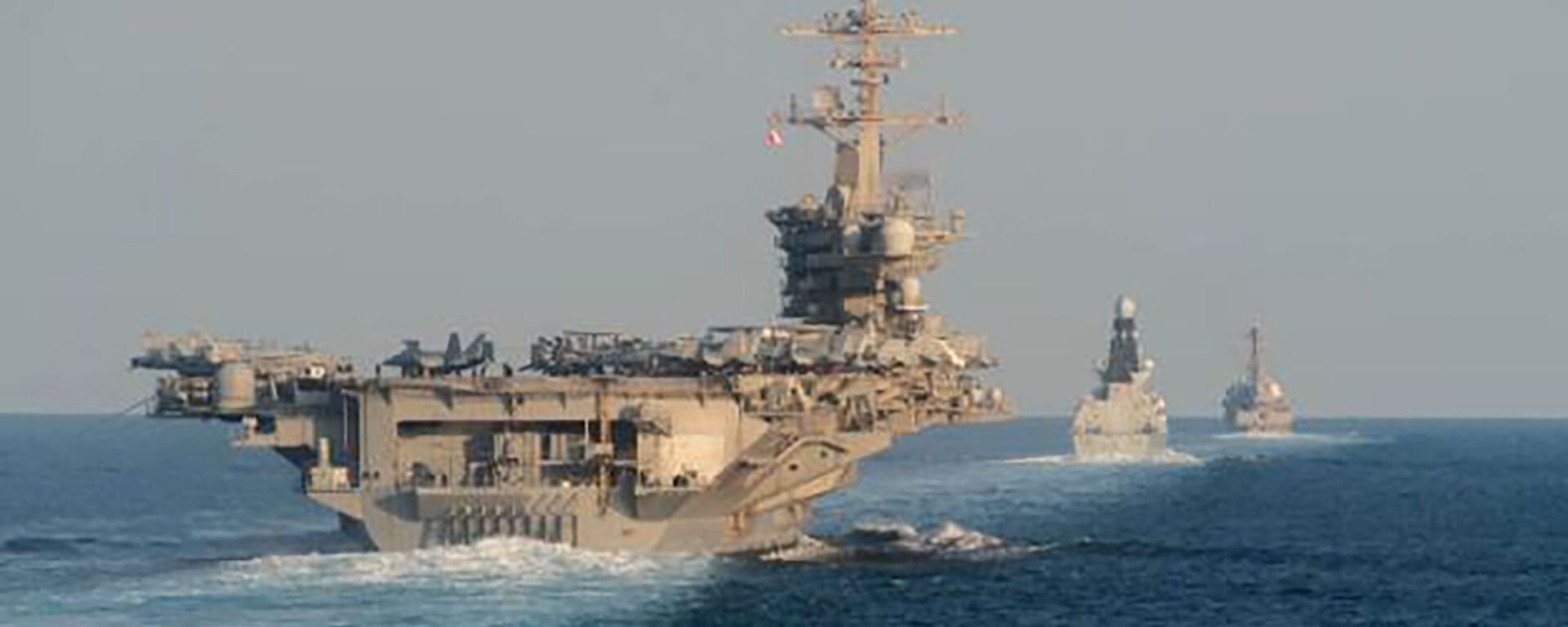 In this Tuesday, Nov. 19, 2019, photo made available by U.S. Navy, the aircraft carrier USS Abraham Lincoln, left, the air-defense destroyer HMS Defender and the guided-missile destroyer USS Farragut transit the Strait of Hormuz with the guided-missile cruiser USS Leyte Gulf. - Sputnik International, 1920, 12.11.2024