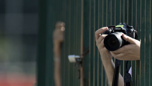 A photographer takes pictures with a Nikon D7100 camera during the third practice session at the Spa-Francorchamps circuit in Spa on August 27, 2016 ahead of the Belgian Formula One Grand Prix - Sputnik International