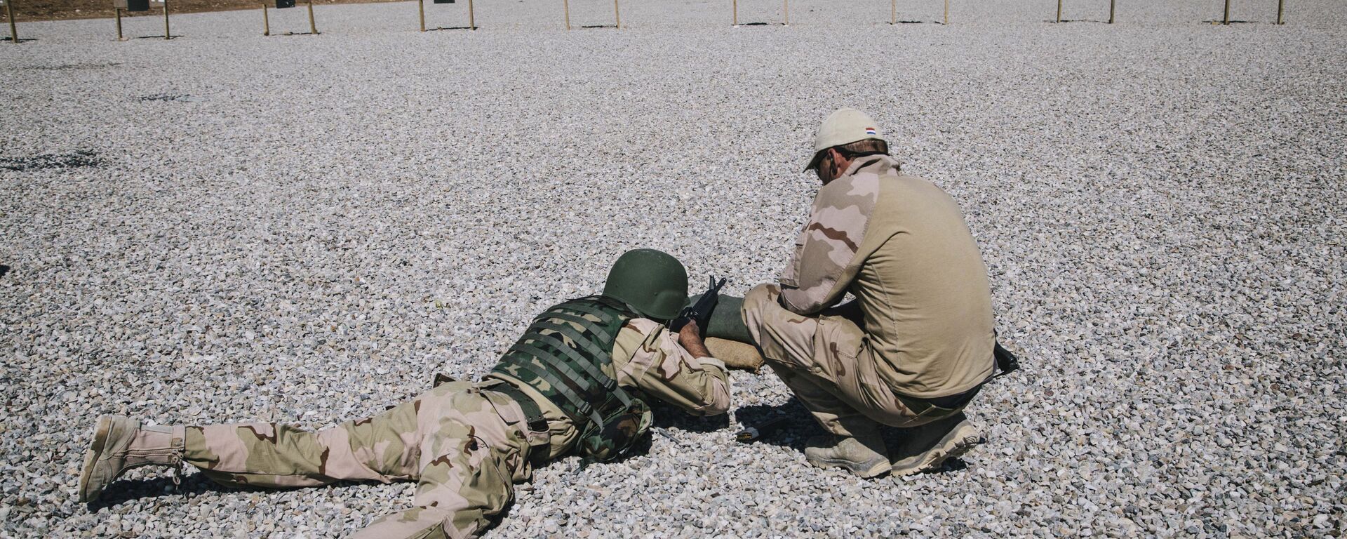 In this March 9, 2016 file image, a Dutch army trainer, right, helps a Kurdish Peshmerga soldier during a military training session at a shooting range, at Bnaslawa Military Base in Irbil, northern Iraq.  - Sputnik International, 1920, 24.01.2025