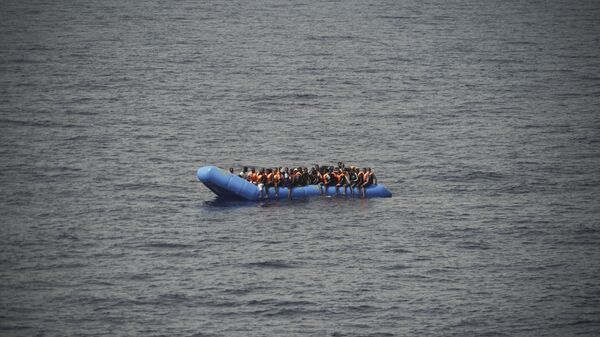 Migrants aboard a blue plastic boat in the Mediterranean Sea - Sputnik International