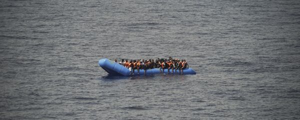 Migrants aboard a blue plastic boat in the Mediterranean Sea Migrants aboard a blue plastic boat in the Mediterranean Sea - Sputnik International