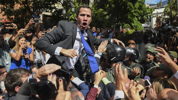 Venezuelan opposition leader and self-proclaimed acting president Juan Guaido shouts surrounded by journalists on his way to the National Assembly, in Caracas, on January 7, 2020. - Sputnik International