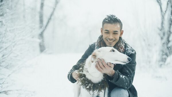 Smiling man with a white dog with winter forest on the background. - Sputnik International