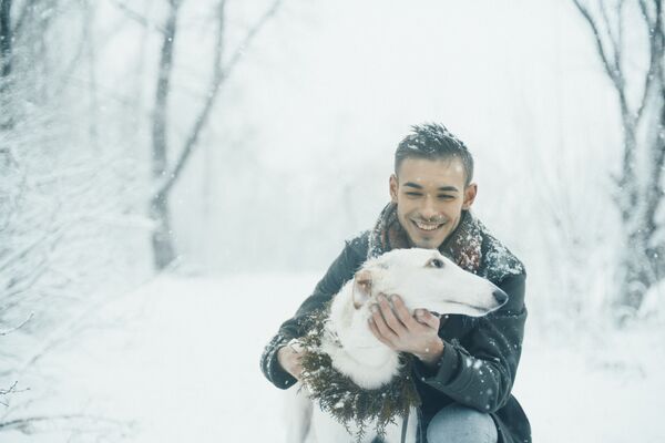 Smiling man with a white dog with winter forest on the background. - Sputnik International
