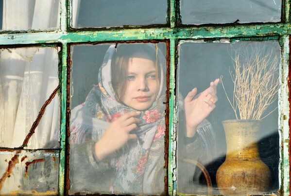 A girl looks out of the window during Christmas fortune-telling in the village of Chernorechye in the Chelyabinsk region. - Sputnik International