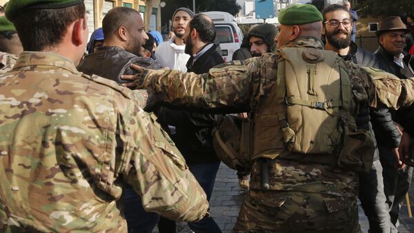 Lebanese army soldier push back the supporters of outgoing Prime Minister Saad Hariri, during an anti-government protest outside of the Beirut municipality in Lebanon, Friday, Jan. 10, 2010. Scuffles broke out between anti—government protesters calling for the ouster of the city's mayor and the governor of the province, and supporters of outgoing Prime Minister Saad Hariri, who handpicked them. - Sputnik International