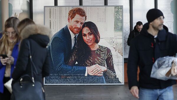 People walk past a picture of Britain's Prince Harry and Meghan Duchess of Sussex, in Windsor, Friday, Jan. 10, 2020. Britain's Prince Harry and his wife, Meghan, said they are planning to step back as senior members of the royal family and work to become financially independent. - Sputnik International