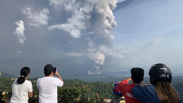 People take photos of a phreatic explosion from the Taal volcano as seen from the town of Tagaytay in Cavite province, southwest of Manila, on January 12, 2020. - Sputnik International