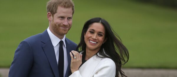 In this file photo Britain's Prince Harry stands with his fiance US actress Meghan Markle as she shows off her engagement ring whilst they pose for a photograph in the Sunken Garden at Kensington Palace in west London on November 27, 2017, following the announcement of their engagement In this file photo Britain's Prince Harry stands with his fiance US actress Meghan Markle as she shows off her engagement ring whilst they pose for a photograph in the Sunken Garden at Kensington Palace in west London on November 27, 2017, following the announcement of their engagement - Sputnik International