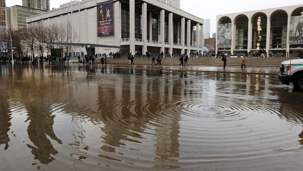 New York's Lincoln Center for the Performing Arts is reflected in a flooded street, in New York, Monday, Jan. 13, 2020. A water main break flooded streets on Manhattan's Upper West Side near Lincoln Center and hampered subway service during the Monday morning rush hour. (AP Photo/Richard Drew) - Sputnik International