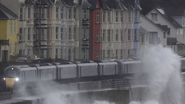 Large waves hit the sea wall with Storm Brendan bringing high winds and heavy rain, as a train passes through Dawlish, southwest Britain, January 14, 2020.  - Sputnik International