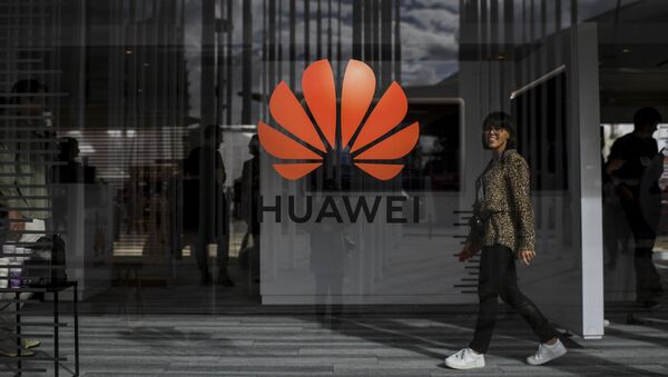 A woman walks past the logo of Chinese telecom giant Huawei during the Web Summit in Lisbon on November 6, 2019 - Sputnik International