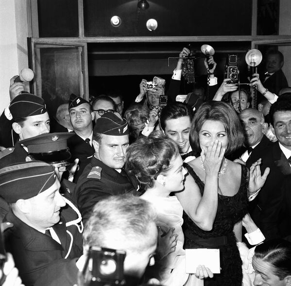Italian Oscar-winning actress Sophia Loren, extreme right, and her company are protected by police from crushing crowds as they arrive at Festival Palace for the opening of the Cannes film festival, May 7, 1962. Next to Miss Loren is actress Romy Schneider and behind them is actor Alain Delon.  - Sputnik International