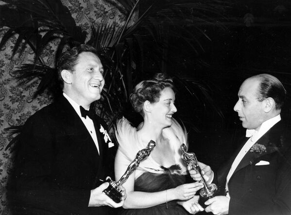 British actor Sir Cedric Hardwicke, right, presents the Oscar to Bette Davis and Spencer Tracy, left, at the 1938 Annual Academy Awards at the Biltmore Bowl, Biltmore Hotel in Los Angeles, Ca., Feb. 23, 1939. Davis, named best actress for her role in Jezebel, and Tracy, named best actor for his role in Boys Town, win an Oscar for their second consecutive year.  - Sputnik International